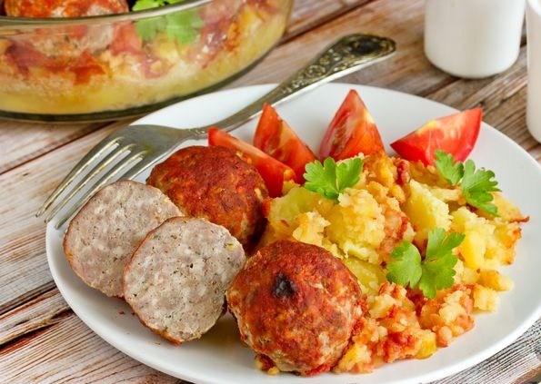 Meatballs baked with potatoes and tomato sauce