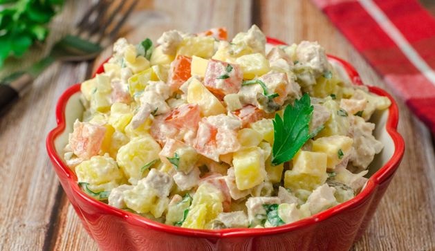 Meat salad with potatoes, tomatoes, pickles and cheese