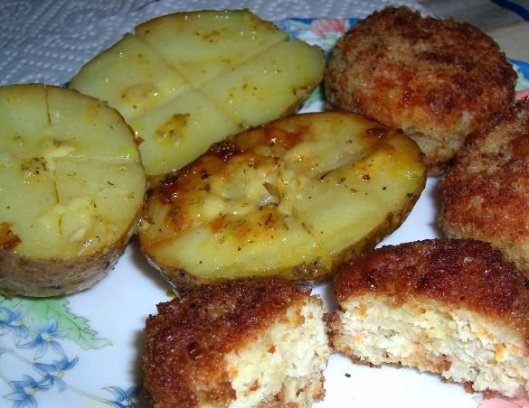Juicy breaded chicken cutlets and baked potatoes with garlic