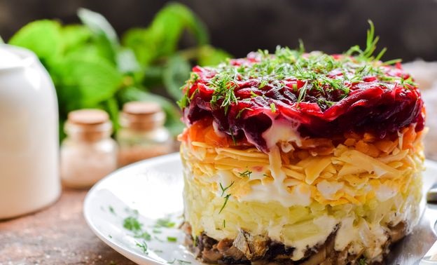 Puff salad with sprats, potatoes, beets, carrots and cheese