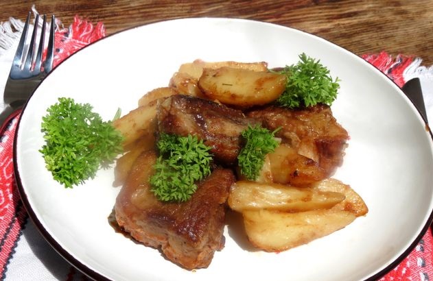 Pork ribs baked with tomato sauce and potatoes