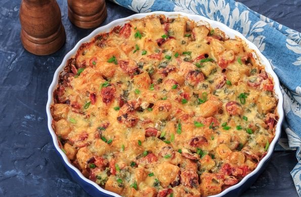 Baked potatoes with sausages, tomatoes and cheese