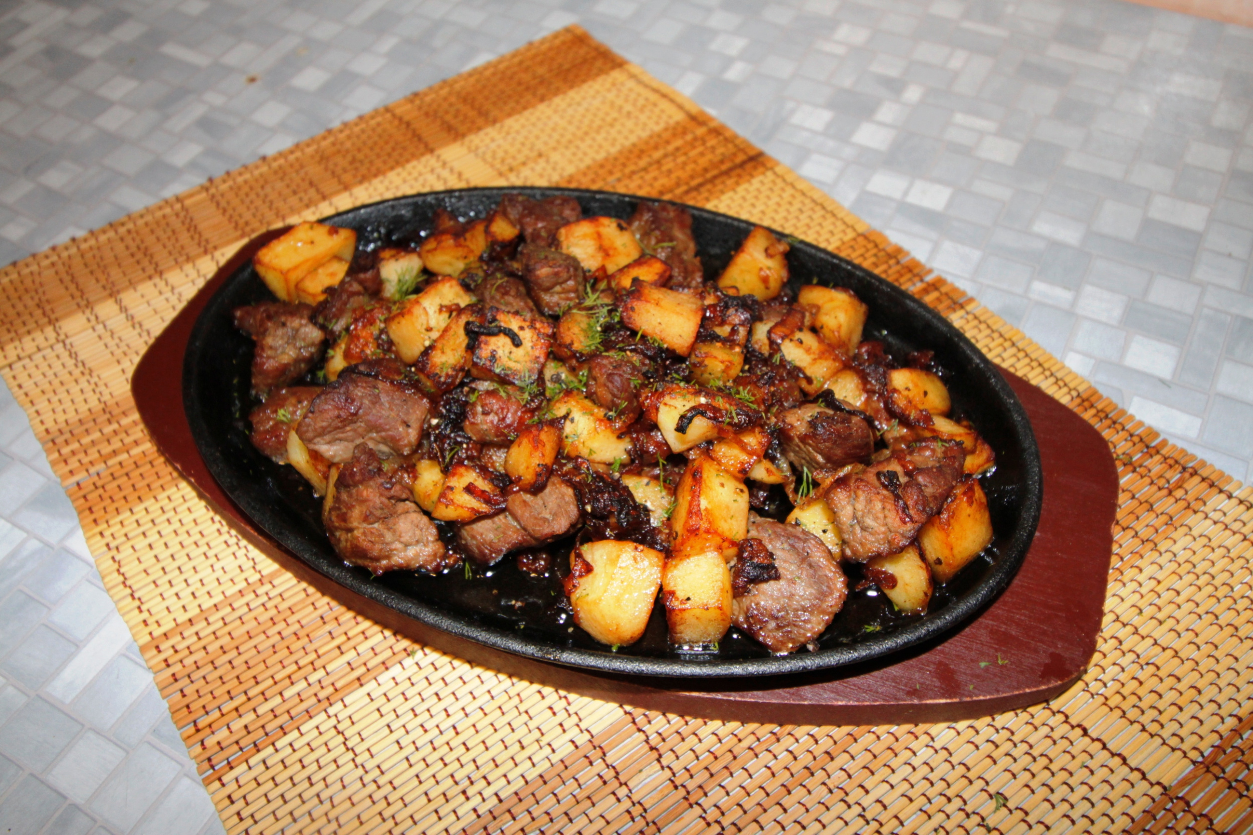Camel meat with onions and potatoes in a brazier