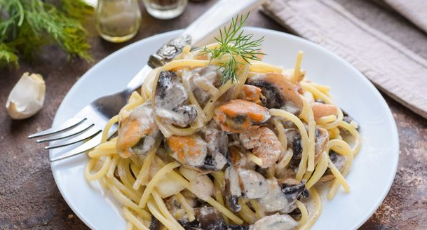 Spaghetti with mushrooms and seafood in a creamy sauce