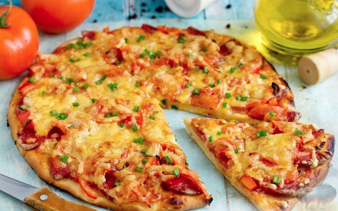 Yeast pizza with sausage, tomatoes and cheese