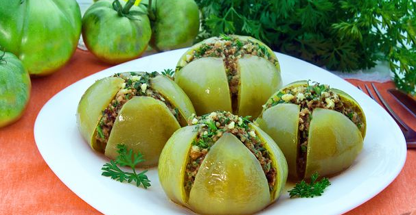 Baked green tomatoes stuffed with parsley, garlic and nuts