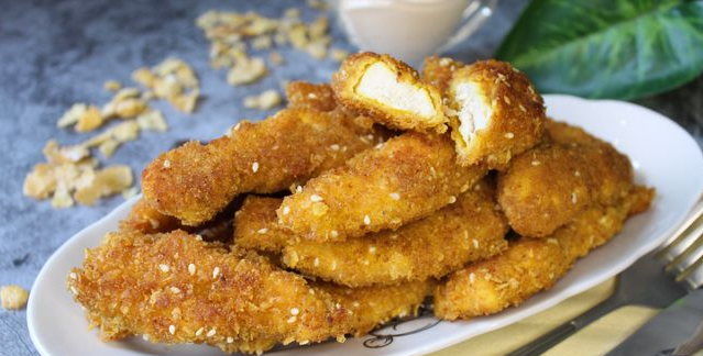 Breaded chicken strips with corn flakes and sesame seeds