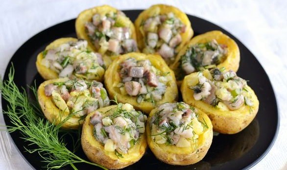 Appetizer of baked potatoes with herring and herbs