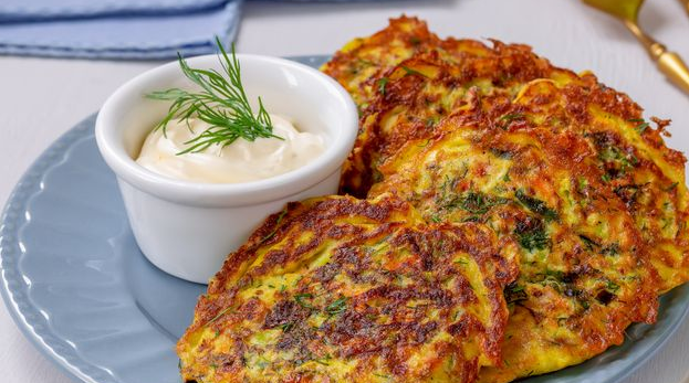 Zucchini pancakes with carrots, sweet peppers, cheese and herbs