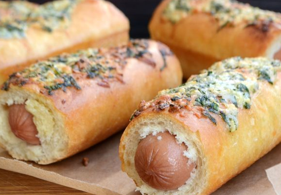 Hot dog in a baguette with garlic and cheese crust
