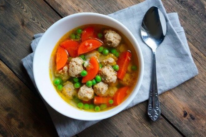 Chicken soup with meatballs and peas