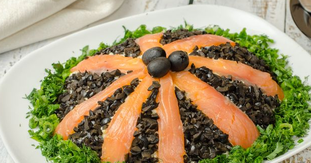 Layered salad with red fish, potatoes, carrots and cucumbers