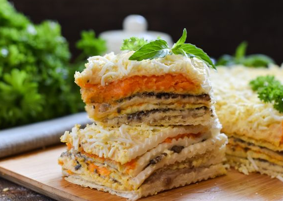 Snack waffle cake with herring, mushrooms and carrots