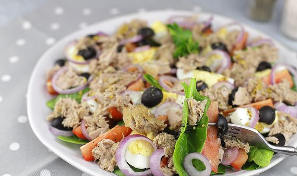 Salad with tuna, eggs, tomatoes, olives, red onion and spinach