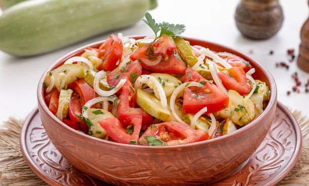 Salad of baked zucchini with tomatoes and onions
