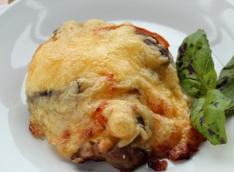 French pork in the oven with mushrooms, tomatoes, cheese