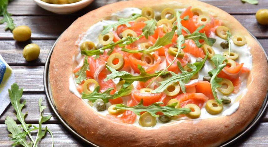 White pizza with salmon, olives and capers