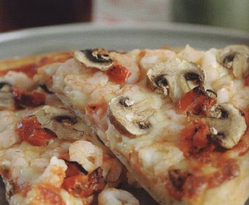 Pizza with mushrooms, shrimps and sun-dried tomatoes