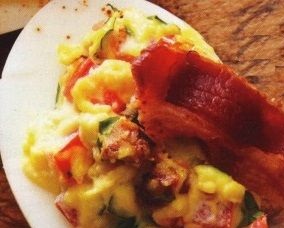 Eggs stuffed with bacon, tomatoes and basil