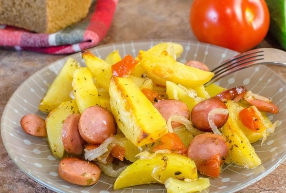 Garlic marinated potatoes baked with sausages and tomatoes