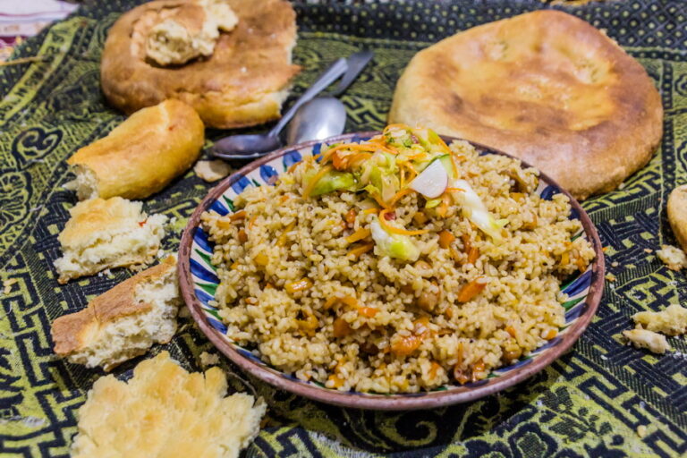 What are the staple ingredients used in Tajik cooking?
