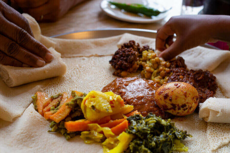 Can you explain the use of injera, a sourdough flatbread, in Eritrean dishes?