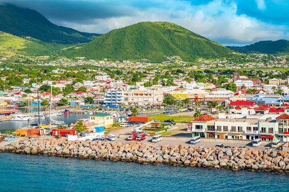 How has the country’s historical background and geographic location influenced Saint Kitts and Nevis cuisine?